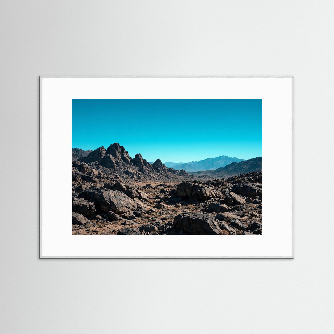 Querformatiges Poster: Felsenlandschaft und Gebirge im hellgrauen Holzrahmen