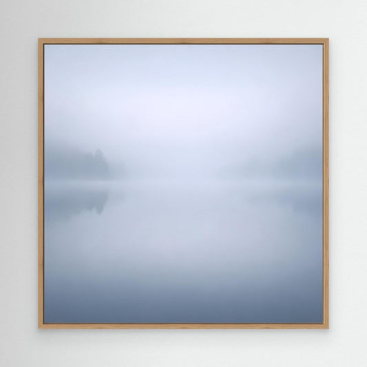 Leinwandbild mit Nebelsee-Motiv, blass blau-grau, Rahmen aus hellem Holz