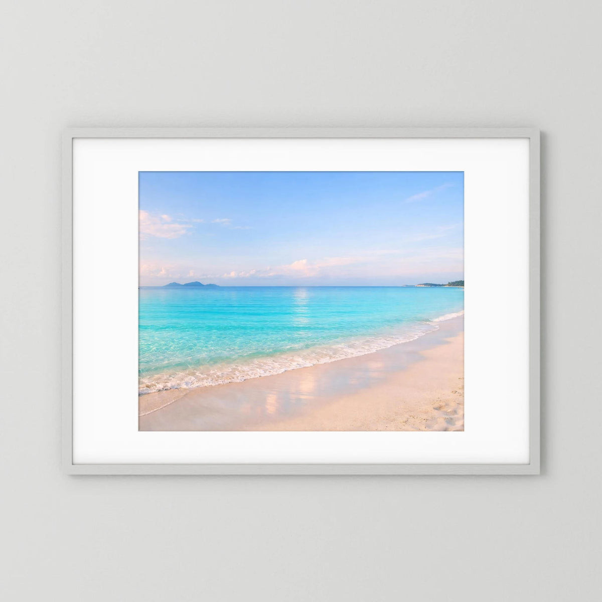 Wandbild mit türkisblauem Sandstrand im Querformat, weißer Rahmen und Rand