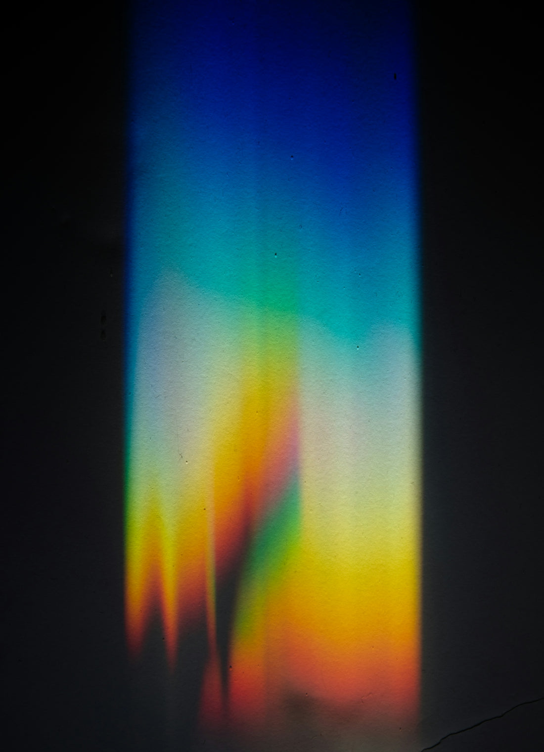 rainbow prism light spectrum on dark surface