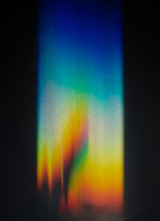 rainbow prism light spectrum on dark surface
