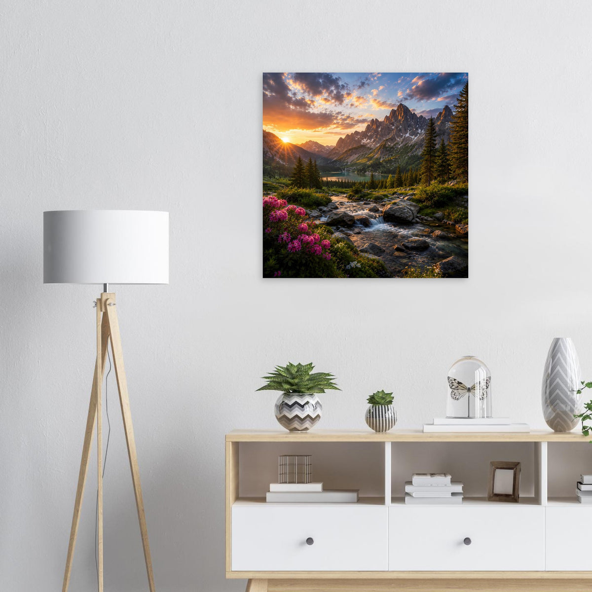 Wandposter mit Landschaft bei Sonnenuntergang: Berge, Bach, Wald und Blüten im schwarzen Rahmen