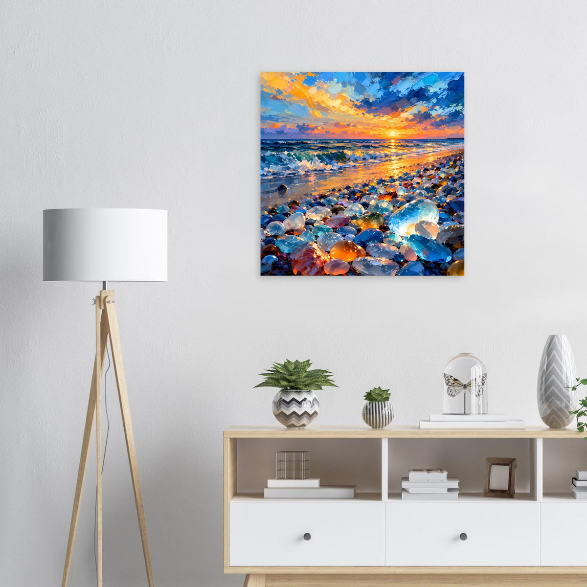 Quadratisches Poster mit Sonnenuntergang über Meer und bunten Steinen im Vordergrund