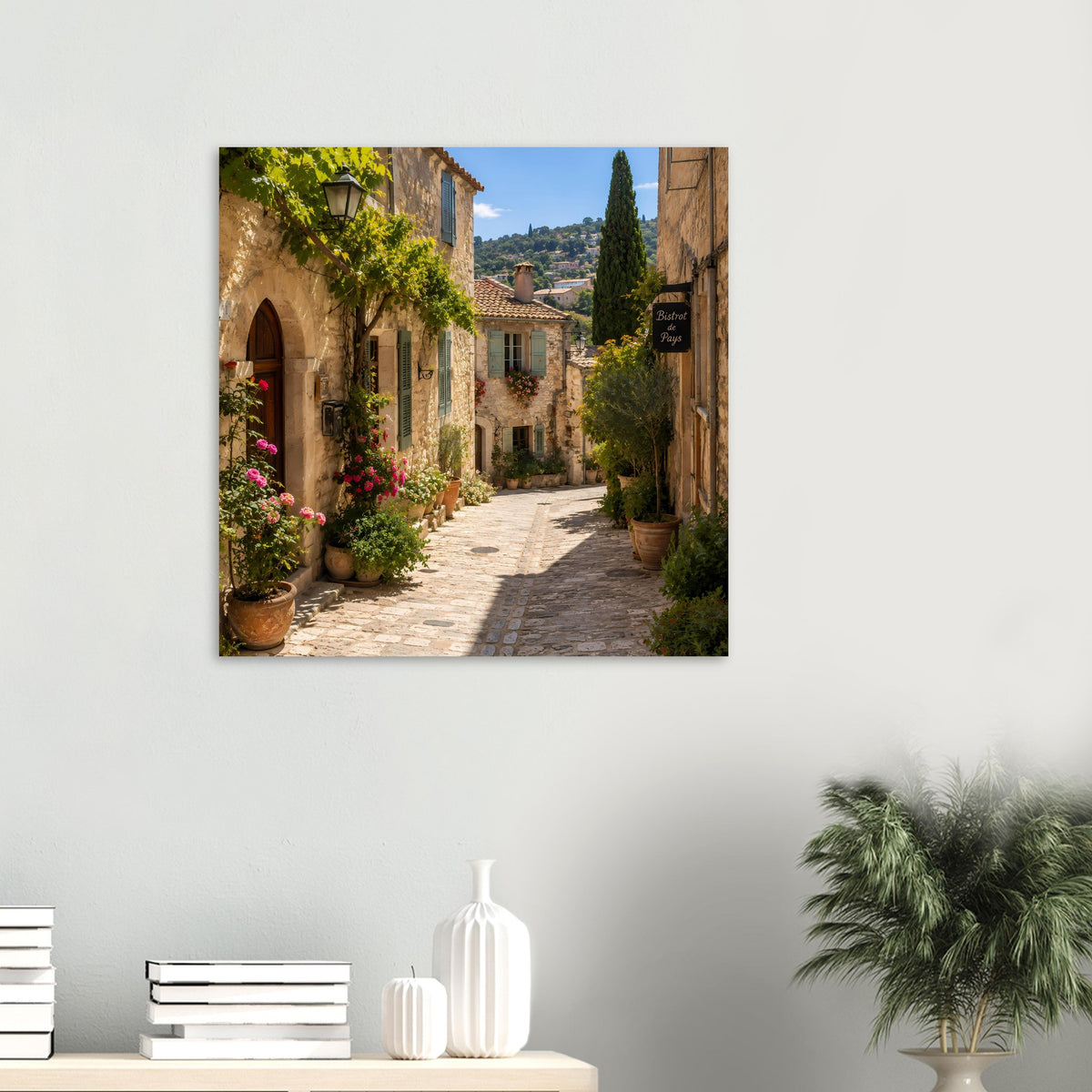 Poster im Rahmen: sonnige Provence-Gasse mit Natursteinhäusern und blühenden Kübeln