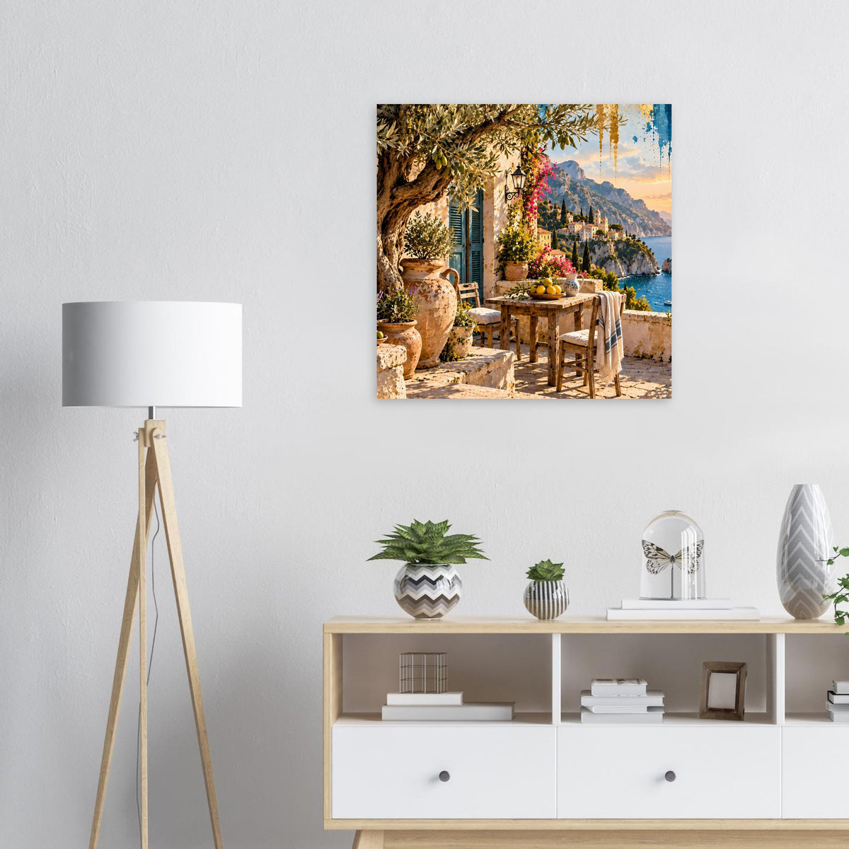 Quadratisches Poster: Küstenterrasse mit Tisch, Blumen, Felsen und warmem Sonnenuntergang