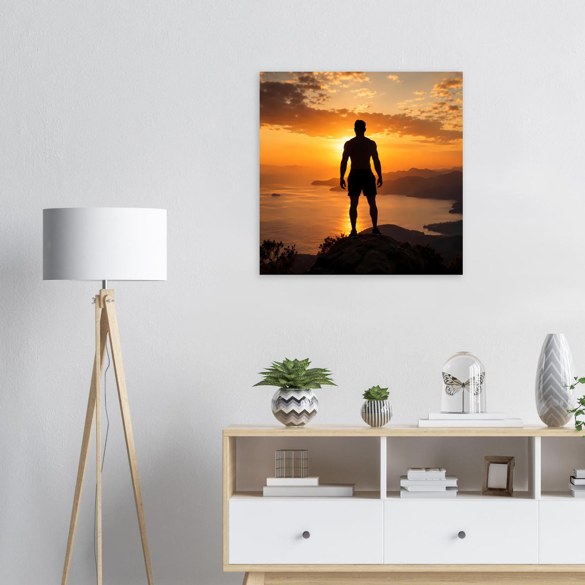 Quadratisches Wandposter mit Silhouette eines Mannes auf Felsen bei Sonnenuntergang
