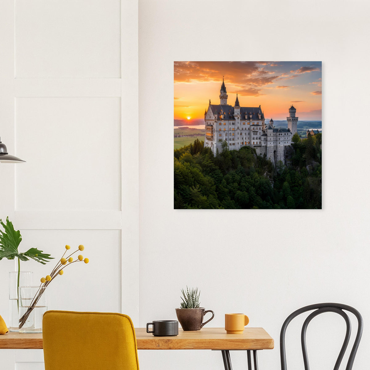Poster mit Schloss bei Sonnenuntergang, an weißer Wand über einer Holzwandfläche.
