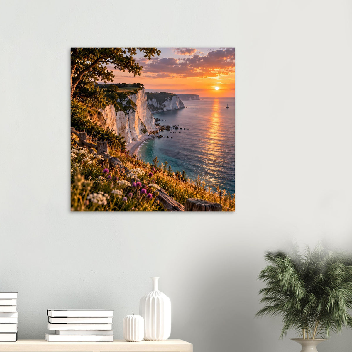 Wandposter mit Küstenfelsen, Blumenhang und Sonnenuntergang über dem Meer.