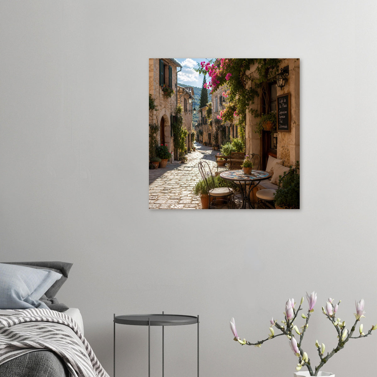 Poster mit sonniger Café-Gasse auf Kopfsteinpflaster, an der Wand hängend