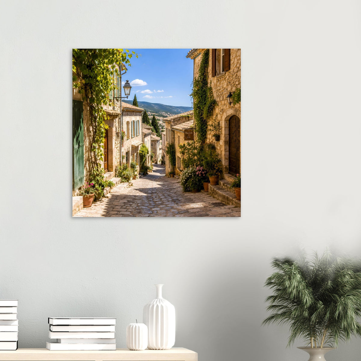 Wandposter mit mediterraner Gasse, aufgehängt über Kommode mit Vasen und Deko