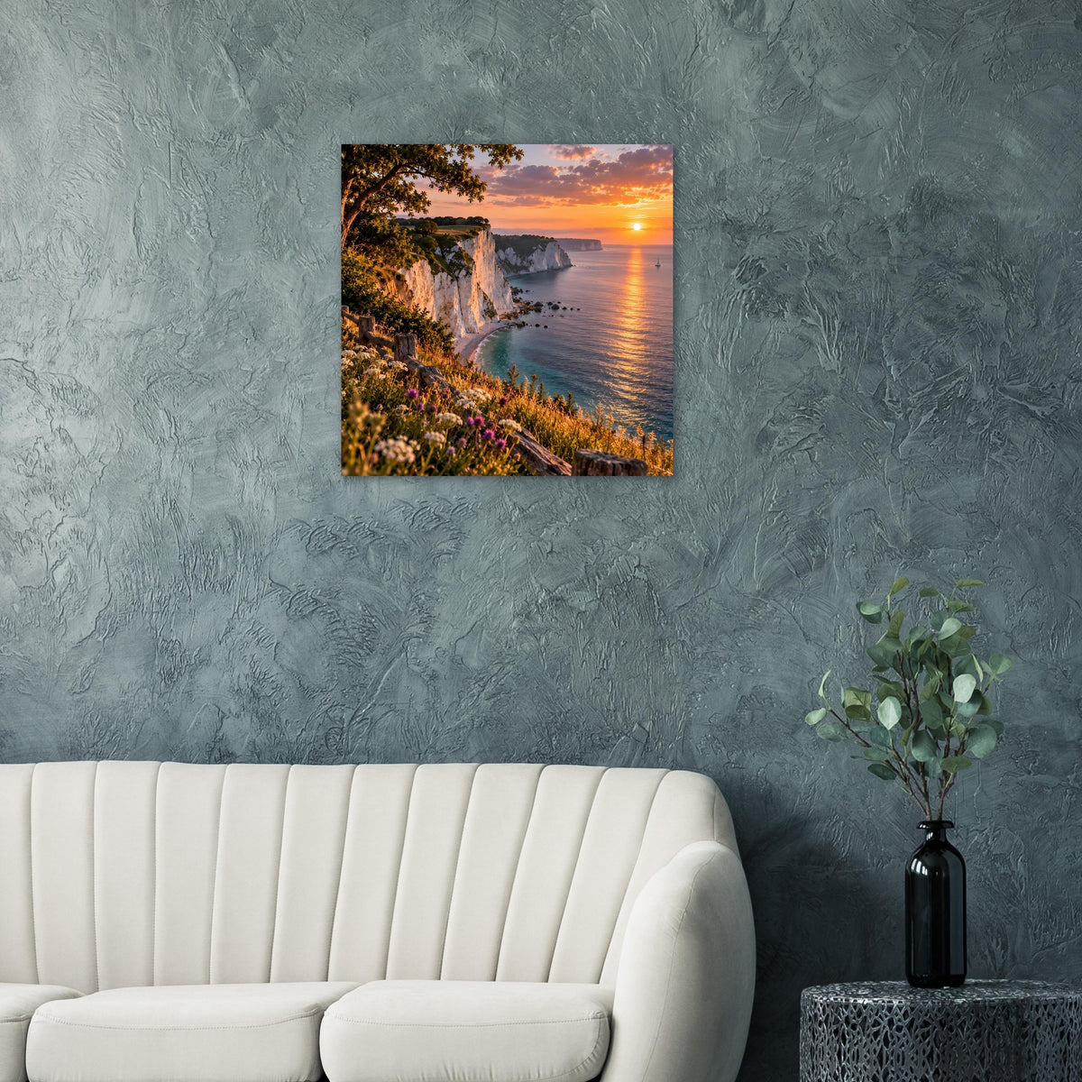 Wandposter mit Küstenklippen, blumenbedecktem Hang und Sonnenuntergang am Meer.
