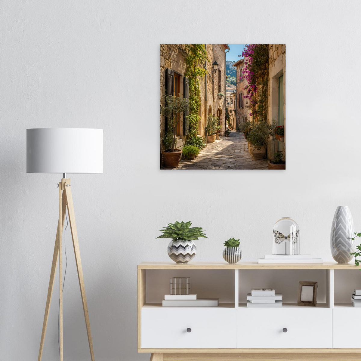 Poster mit mediterraner Gasse, schmaler Straße, Pflanzen und blühenden Fassaden im dunklen Rahmen