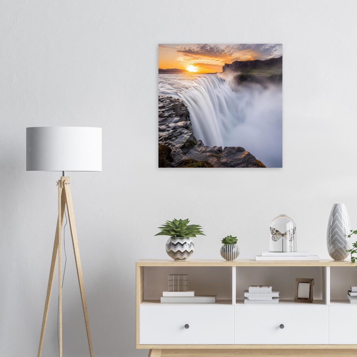 Quadratisches Poster zeigt Wasserfall bei Sonnenuntergang über Felsen.