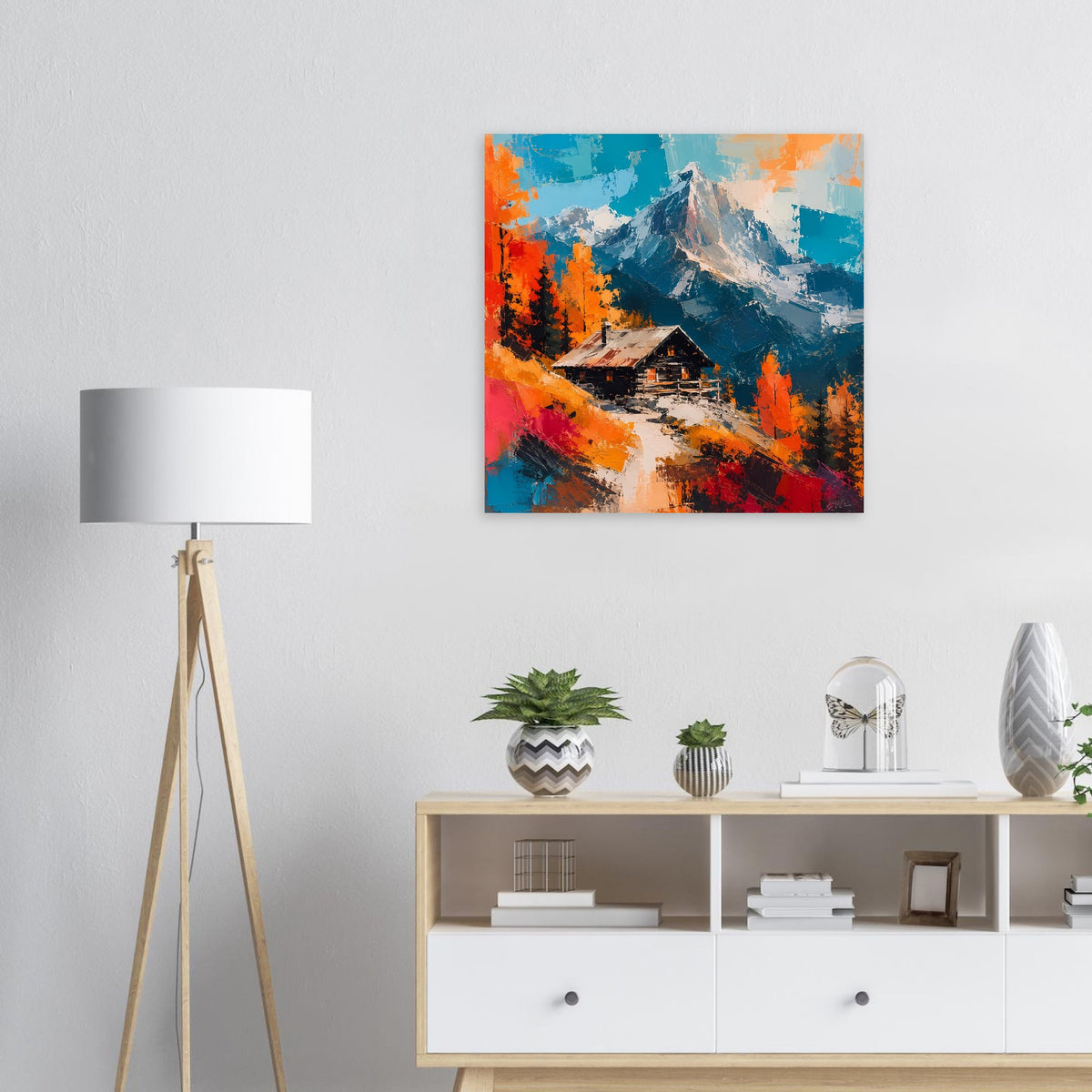 Quadratisches Wandposter mit Berggipfel, Laubbäumen und Hütte in kräftigen Farben.