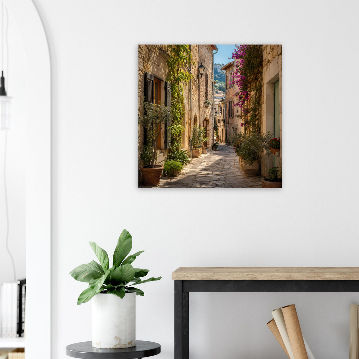 Poster mit mediterraner Gasse, Pflanzen in Töpfen, Kopfsteinpflaster und Blumen im dunklen Rahmen