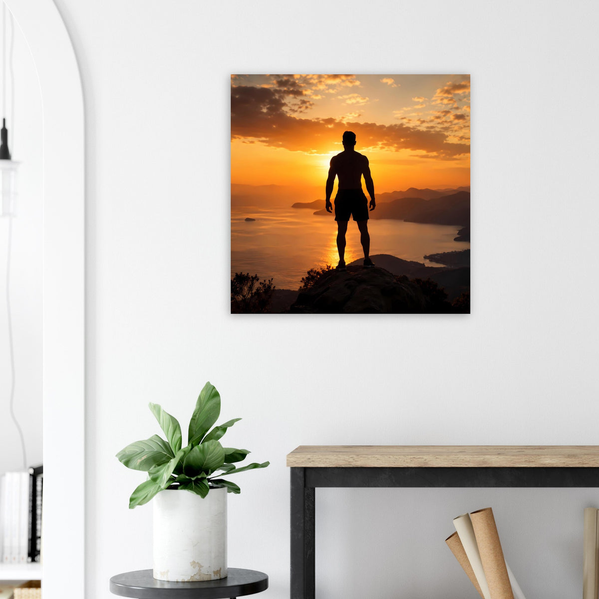 Wandbild im Quadratformat mit Silhouette auf Felsen, Sonnenuntergang mit orangefarbenem Himmel