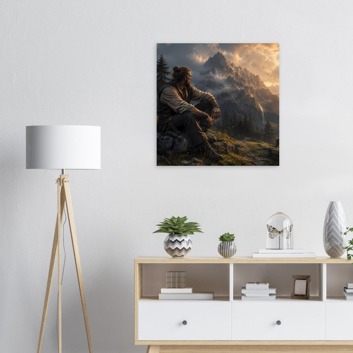 Gerahmtes Poster mit sitzendem Mann vor Berggipfeln und goldenem Himmel