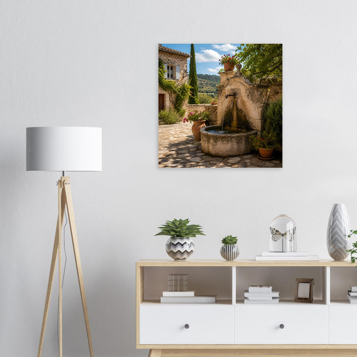 Quadratisches Poster: mediterraner Steinbrunnen mit Efeu, Topfpflanzen und Gehweg