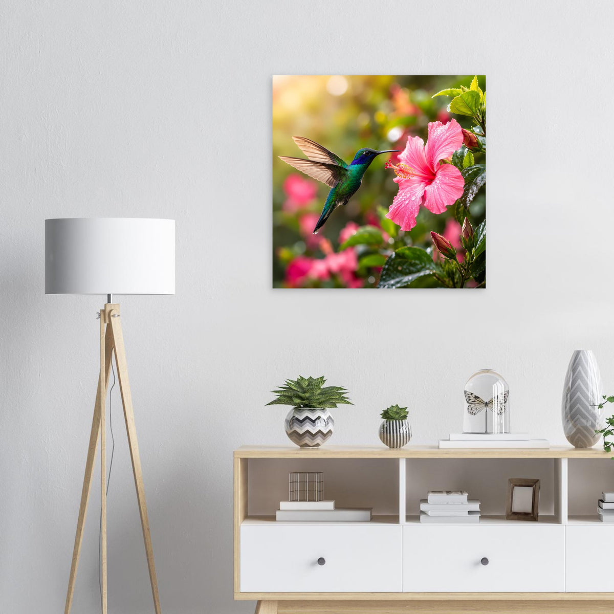 Quadratisches Poster: Kolibri fliegt zwischen grünen Blättern und rosa Hibiskusblüten