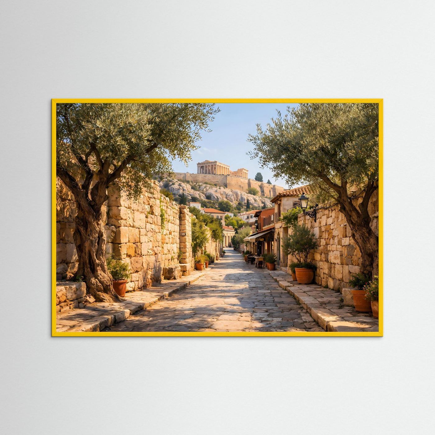 Wandbild mit mediterraner Gasse, Olivenbäume und Steinstraße, gelber Rahmen.