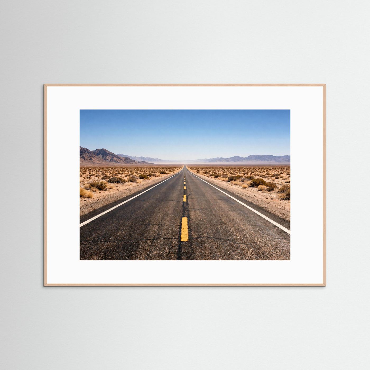 Wandbild mit Foto einer langen Straße durch die Wüste, im naturfarbenen Holzrahmen