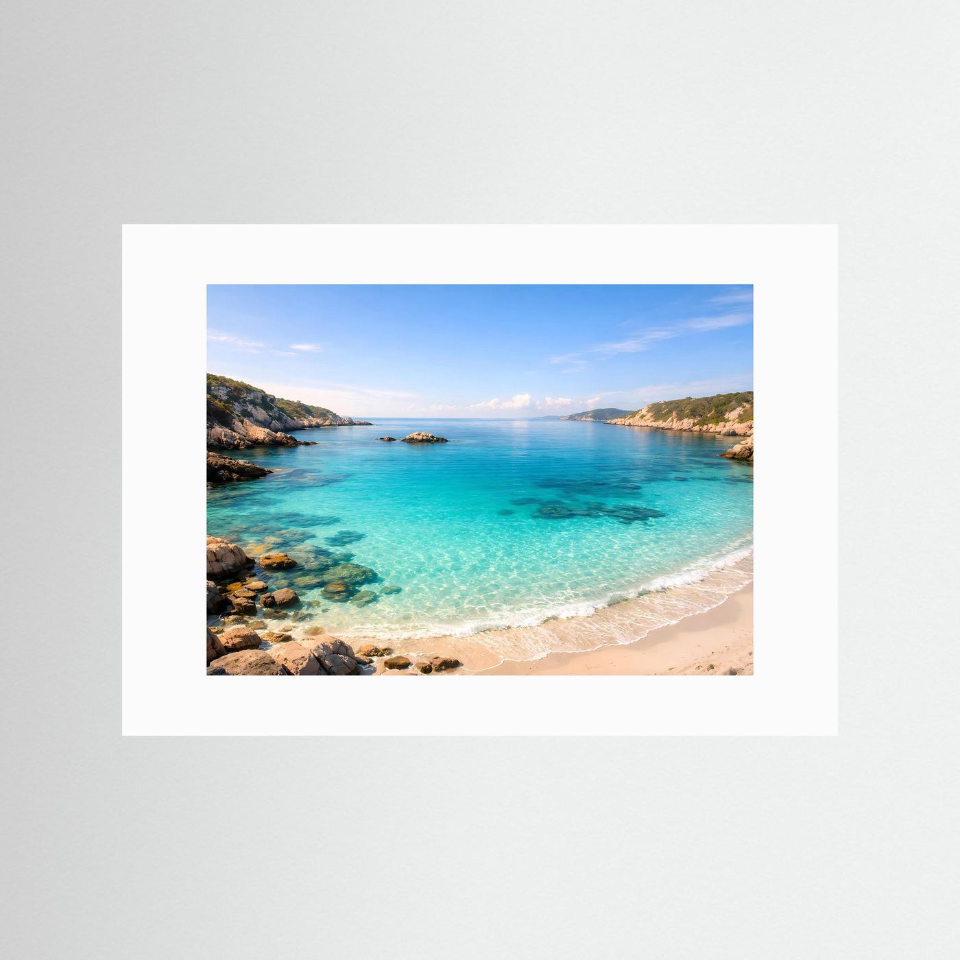 Meerstrand-Poster quer mit weißem Passepartout: türkisblaues Wasser, Sandstrand und Felsen.
