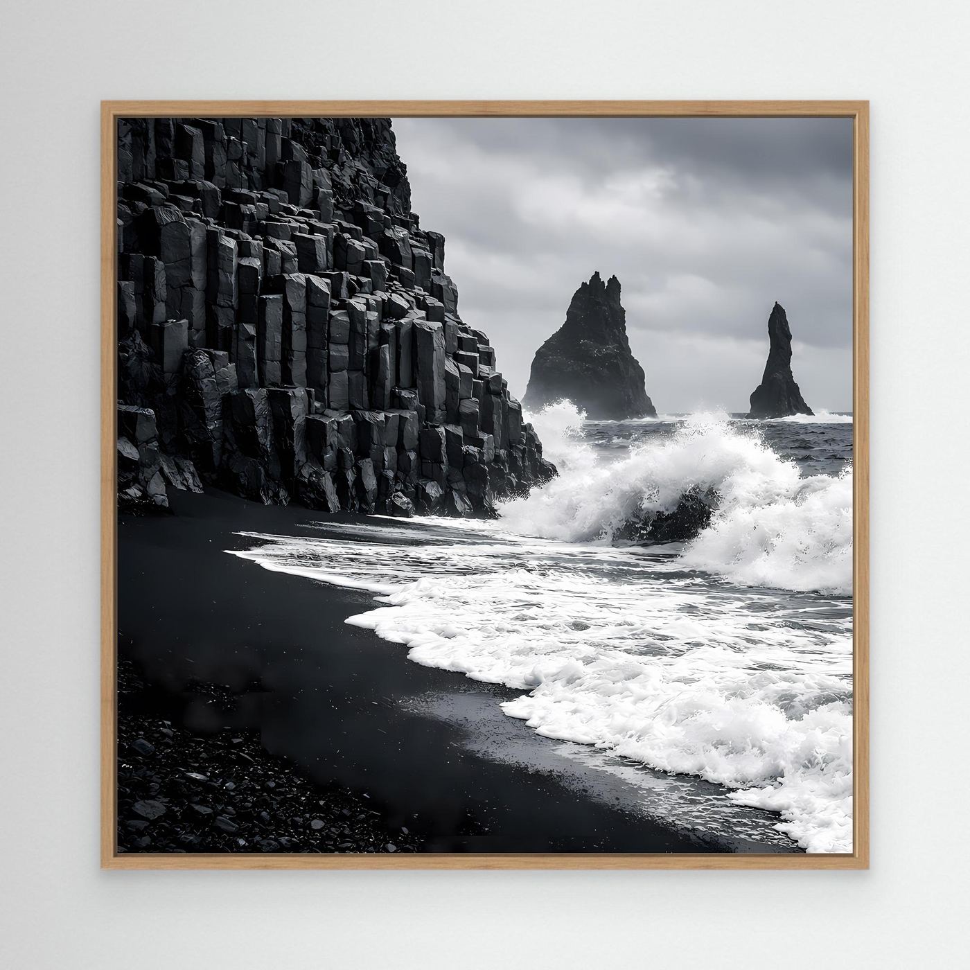 Leinwandbild mit Holzrahmen: schwarzer Sandstrand und Basaltsäulen, Brandung in Schwarzweiß