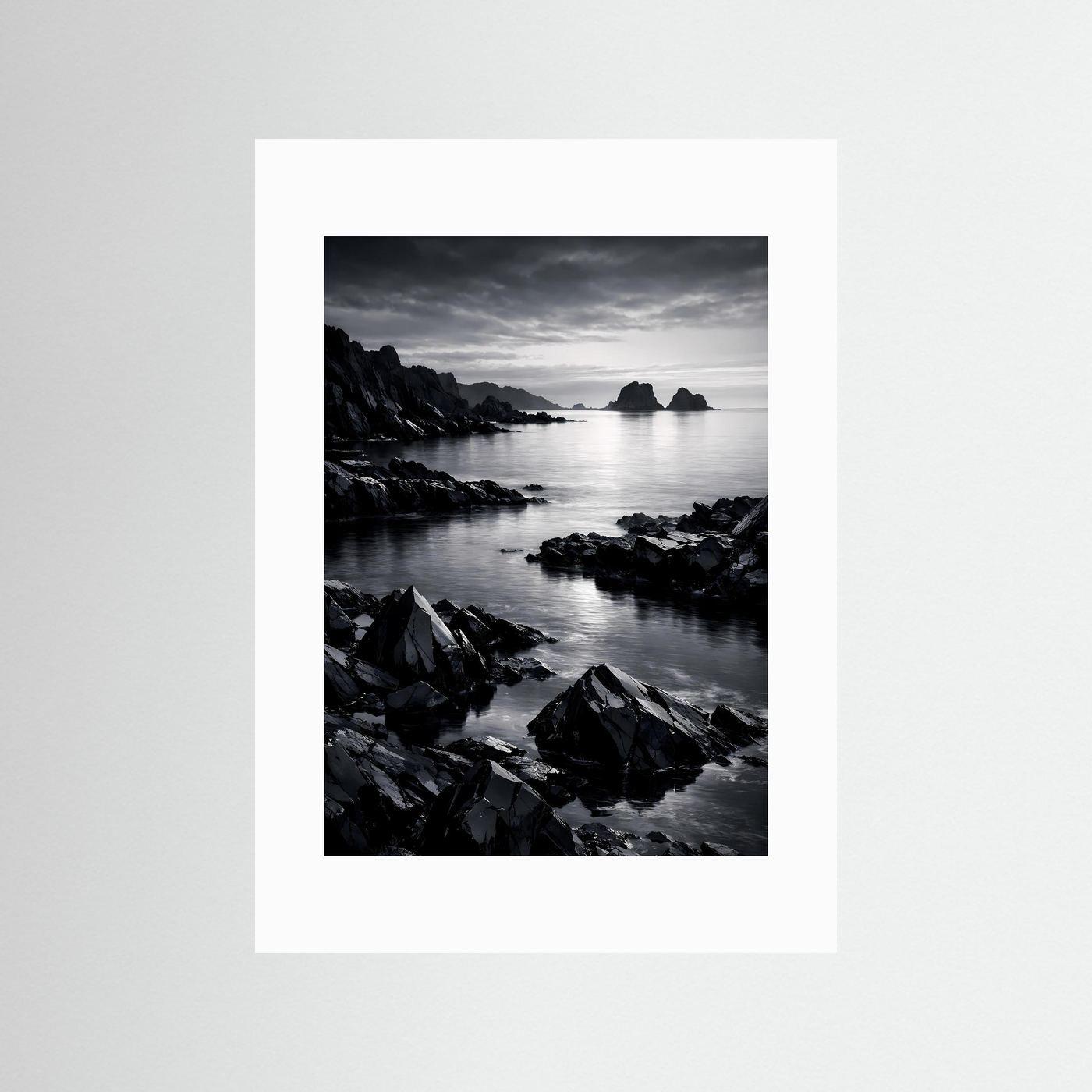 Wandbild Schwarz-Weiß-Küste mit Felsen am Meer, Wolkenhimmel; weißer Rahmen