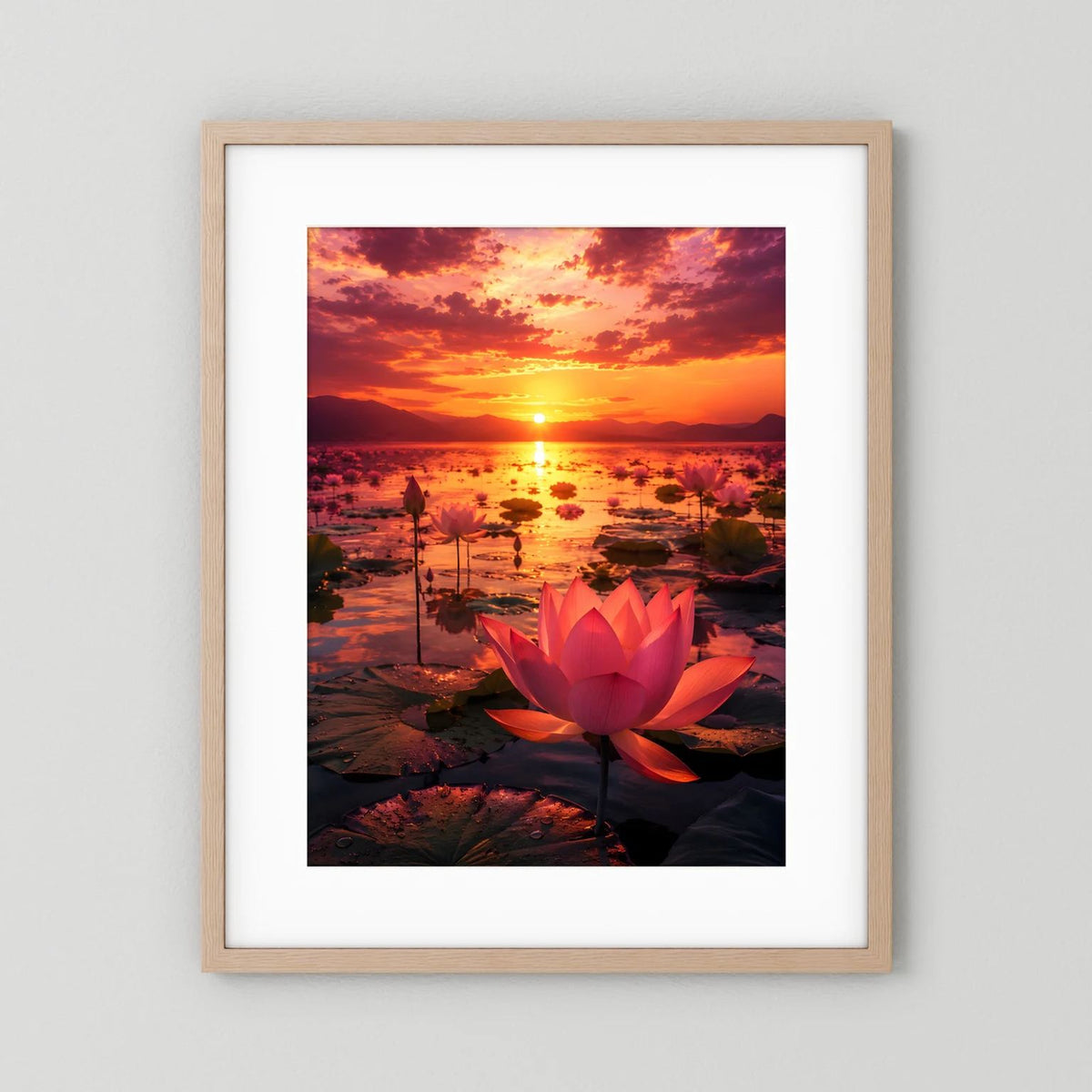 Poster mit roter Lotusblüte und Sonnenuntergang, im hellen Holzrahmen mit weißem Rand.
