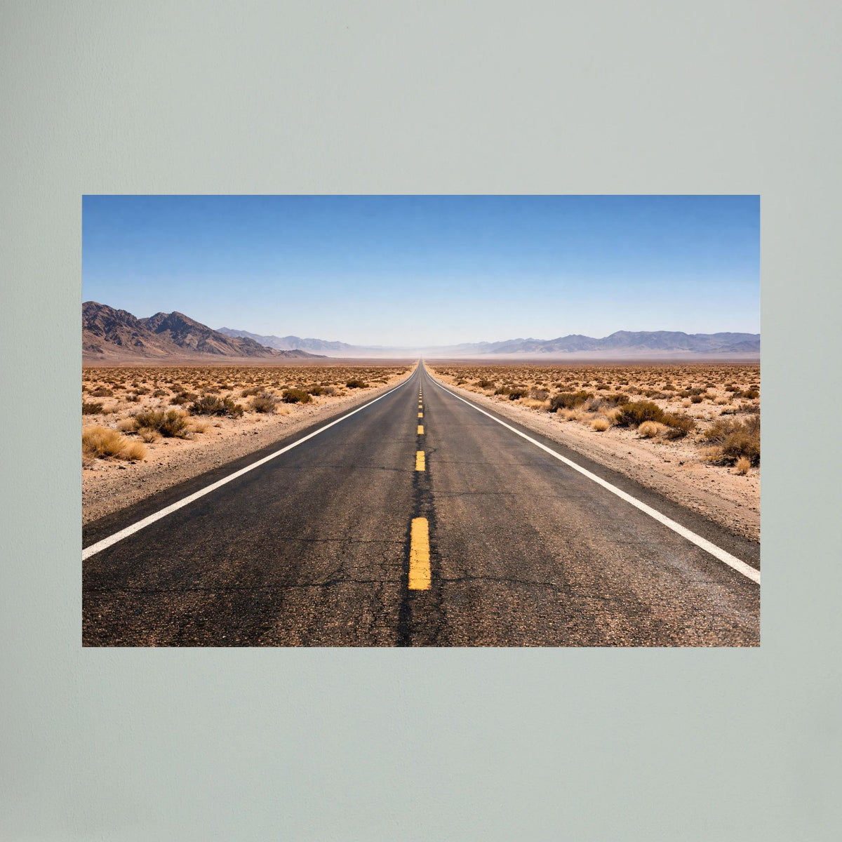 Wandbild im Querformat: Straße in der Wüste, karge Umgebung und klarer blauer Himmel.