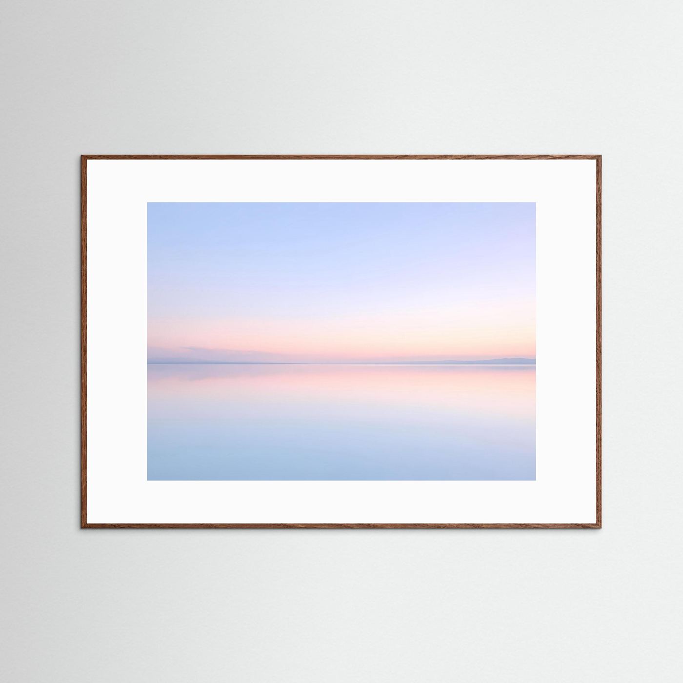 Querformatposter mit pastellfarbener Seespiegelung, braune Holzrahmenleiste und weißem Passepartout