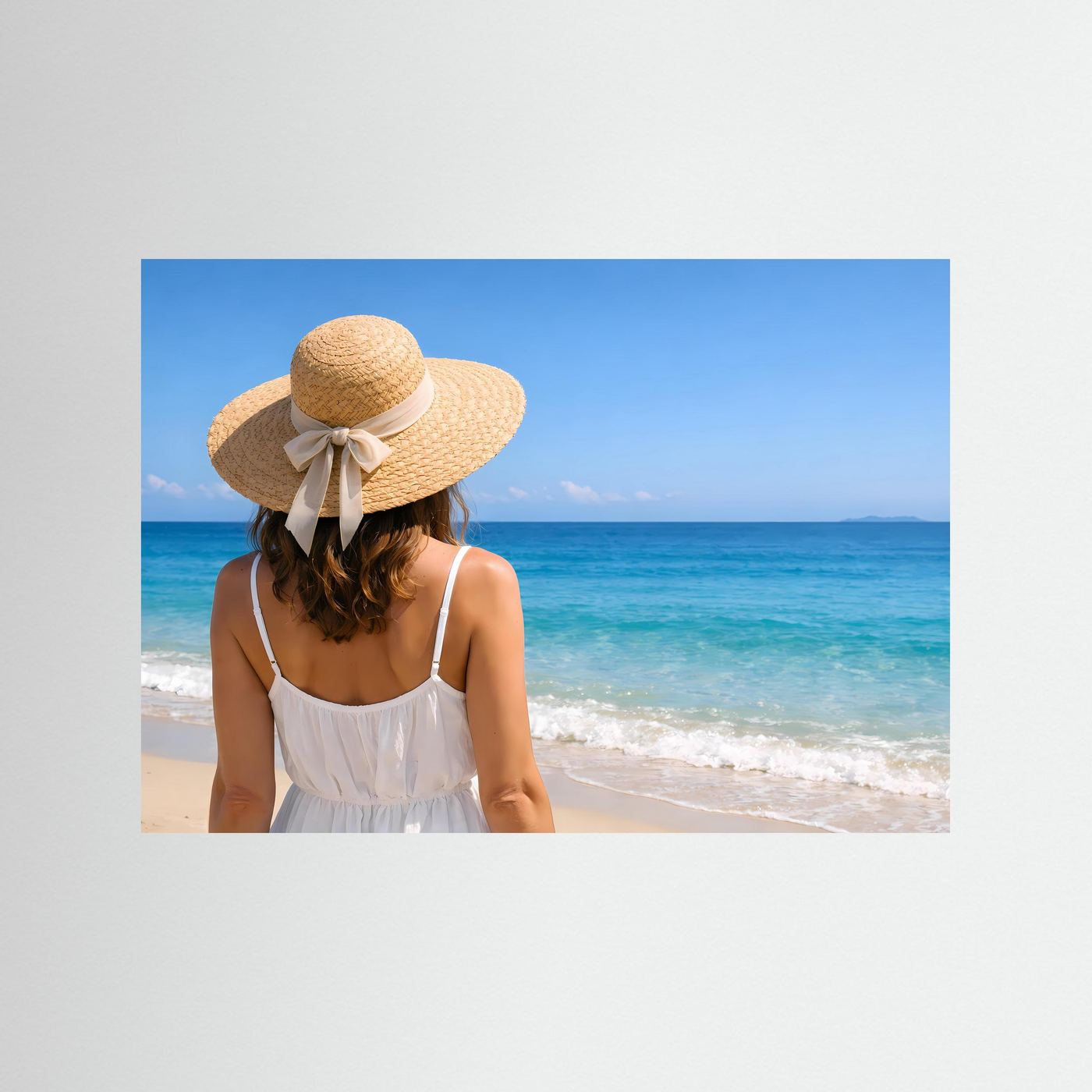 Strandposter im Querformat: Frau mit Strohhut und weißem Kleid am Meer