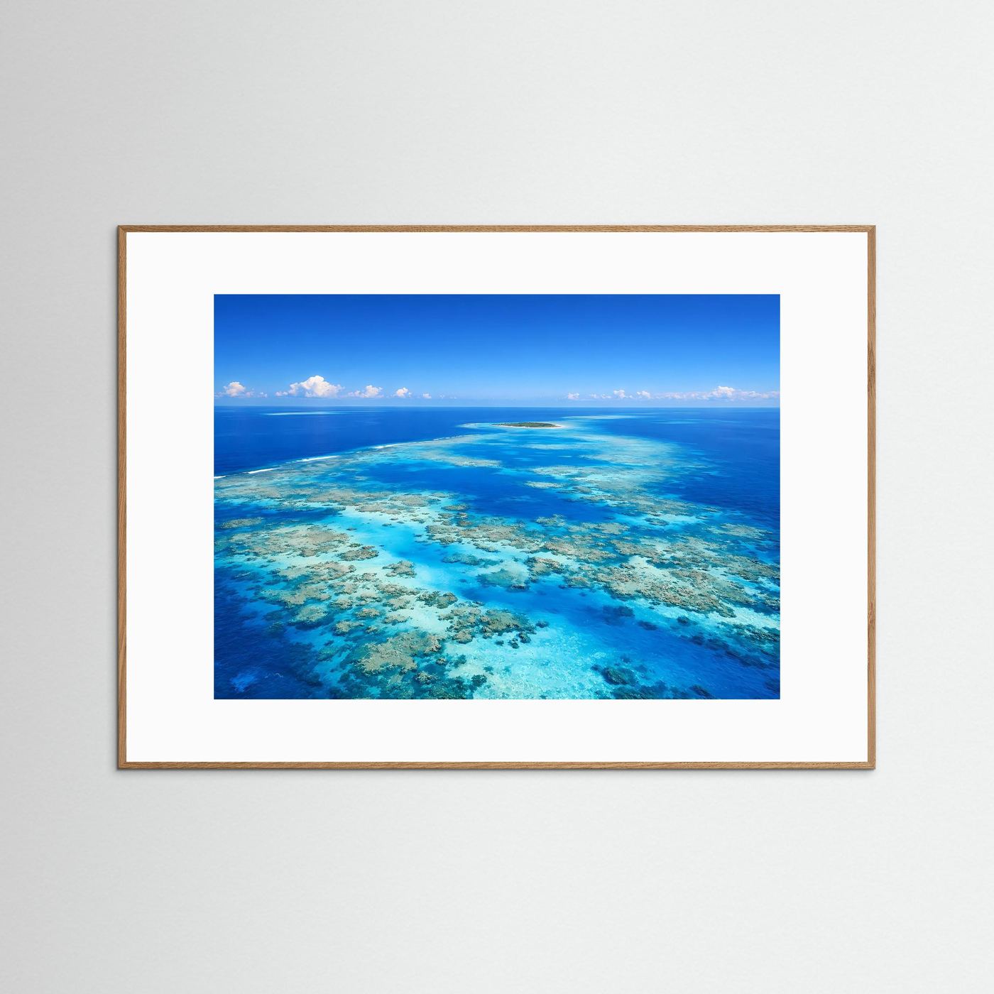 Wandbild mit Korallenriff im türkisblauen Meer, brauner Holzrahmen und weißer Rand