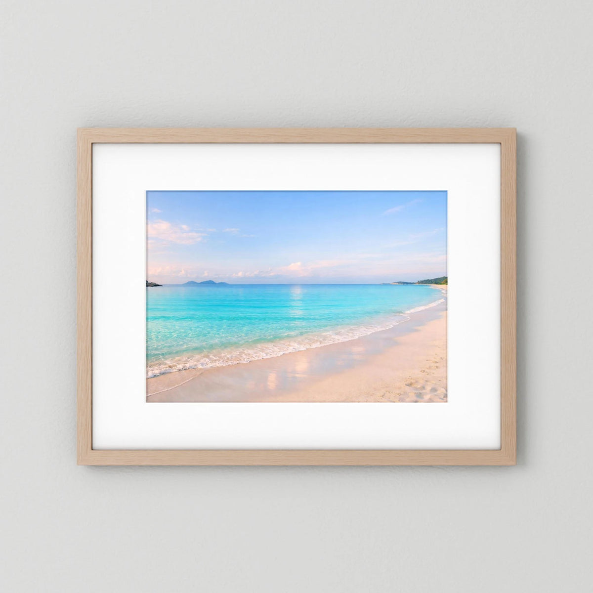 Wandbild mit pastellblauem Sandstrand im Querformat, Holzrahmen, klares Bildausschnitt