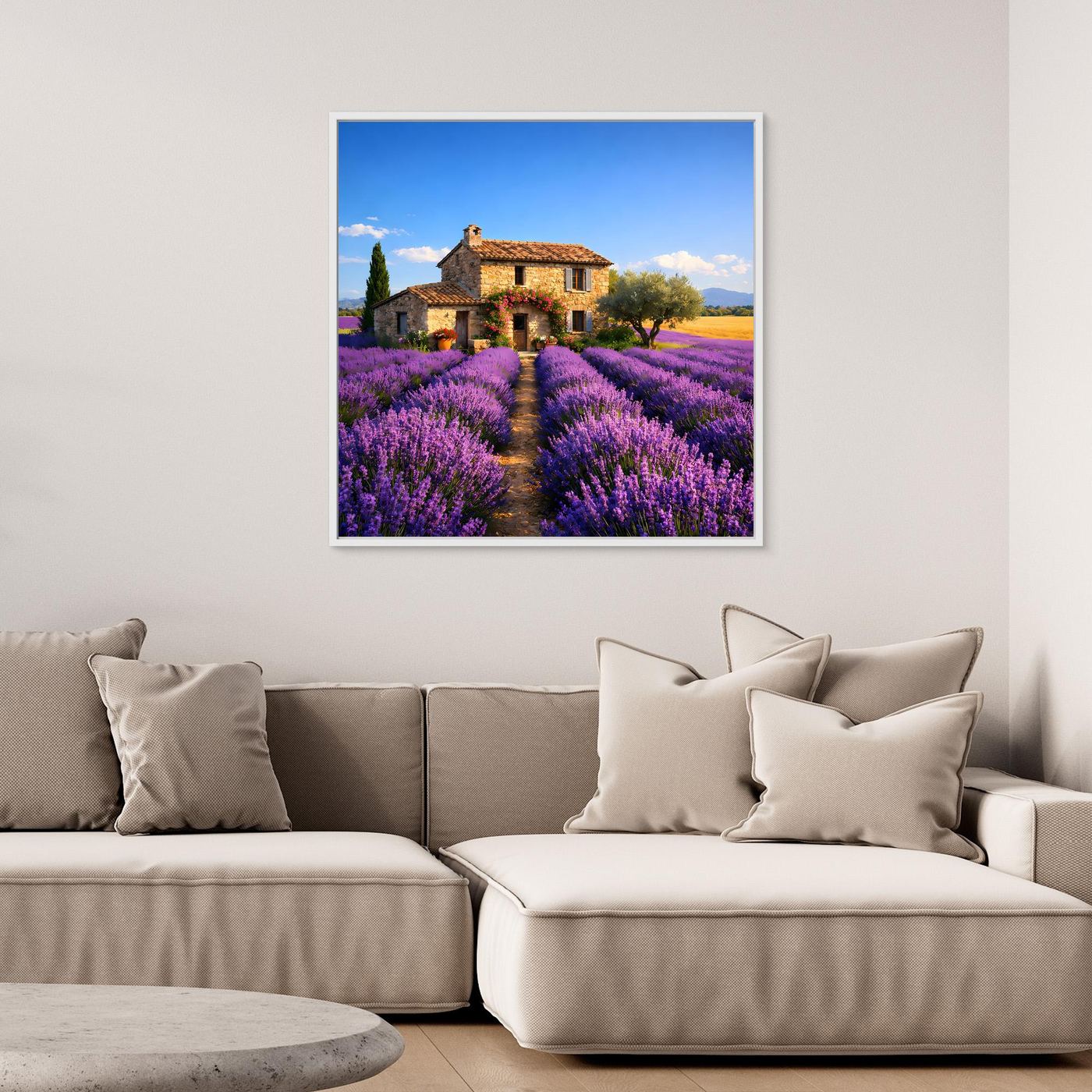 Quadratisches Leinwandbild mit Lavendelfeld und Bauernhaus über Ecksofa an der Wand