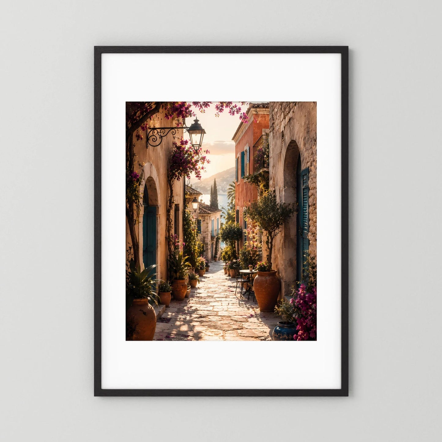 Hochformat-Poster mediterrane Gasse mit Bögen, Pflanzen und violetten Blüten im schwarzen Rahmen mit Passepartout.