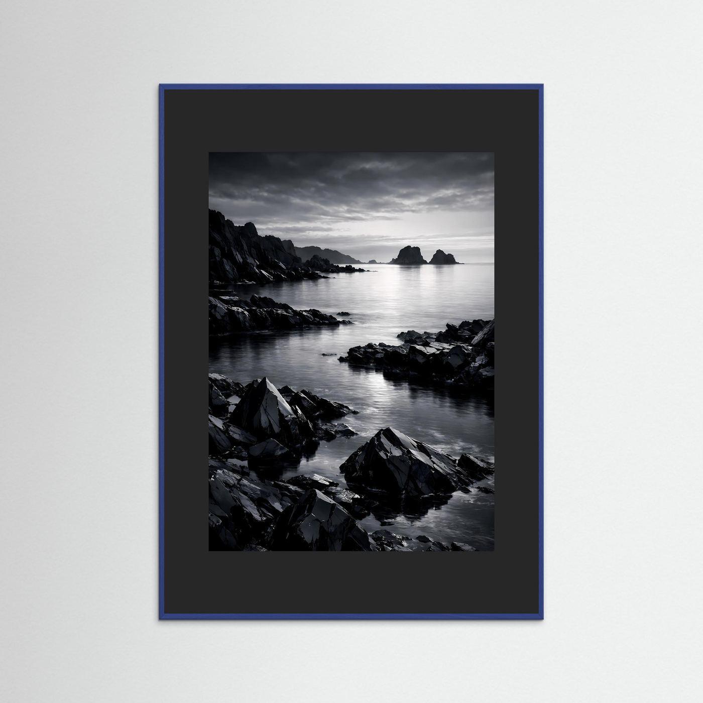 Wandbild Schwarz-Weiß-Küste mit Felsen am Wasser, Insel in der Ferne; blauer Rahmen