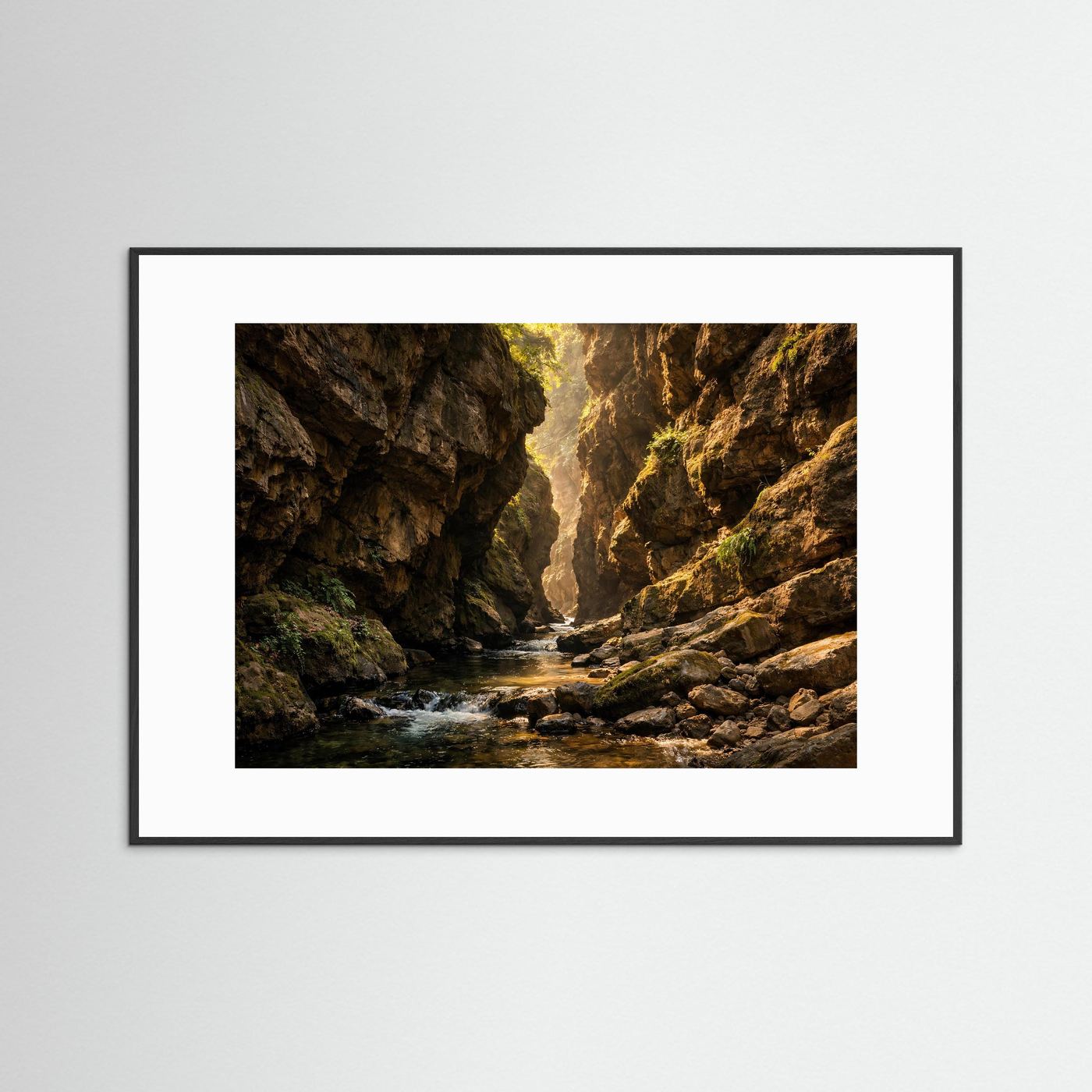 Poster mit Felsenschlucht im Sonnenlicht, Wasserlauf zwischen Felswänden, schwarzer Rahmen