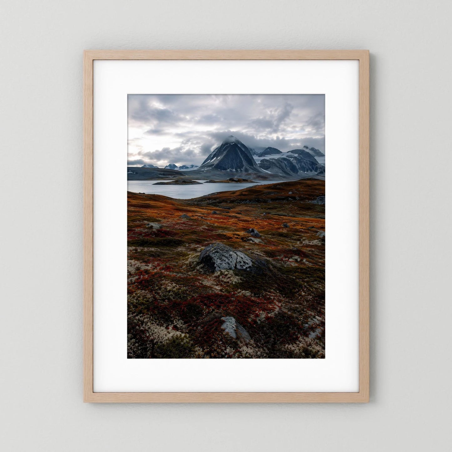 Naturposter im Hochformat mit hellem Holzrahmen und Passepartout, Berglandschaft in Grau/Rostrot