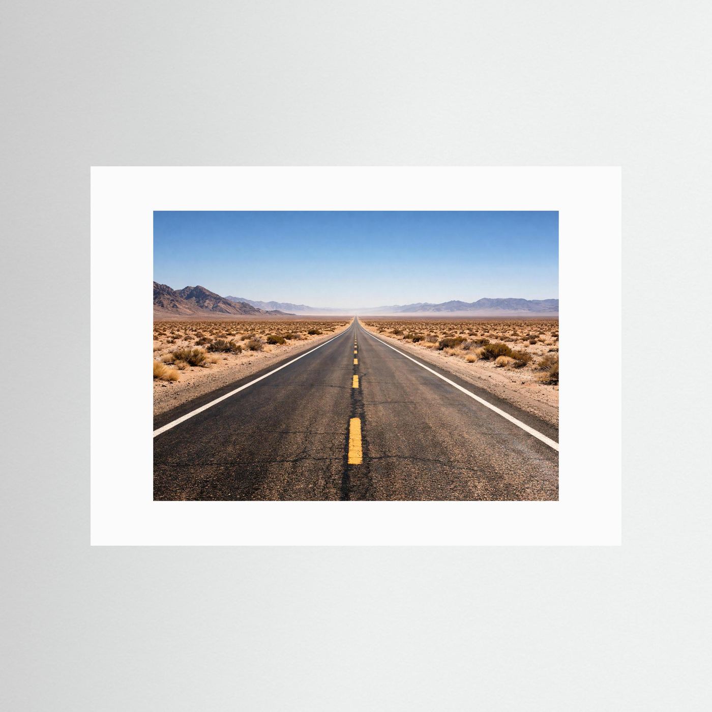 Wandbild mit Foto einer langen Straße durch die Wüste, mit weißem Rand