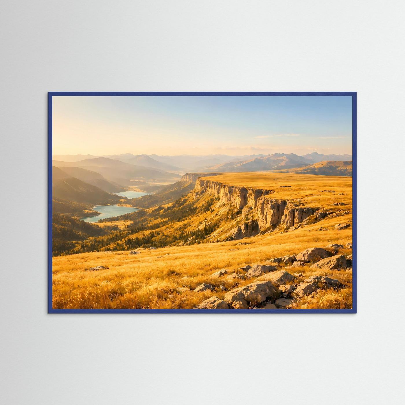 Poster im Querformat mit blauem Rahmen: Klippen und weite Täler in goldenen Tönen