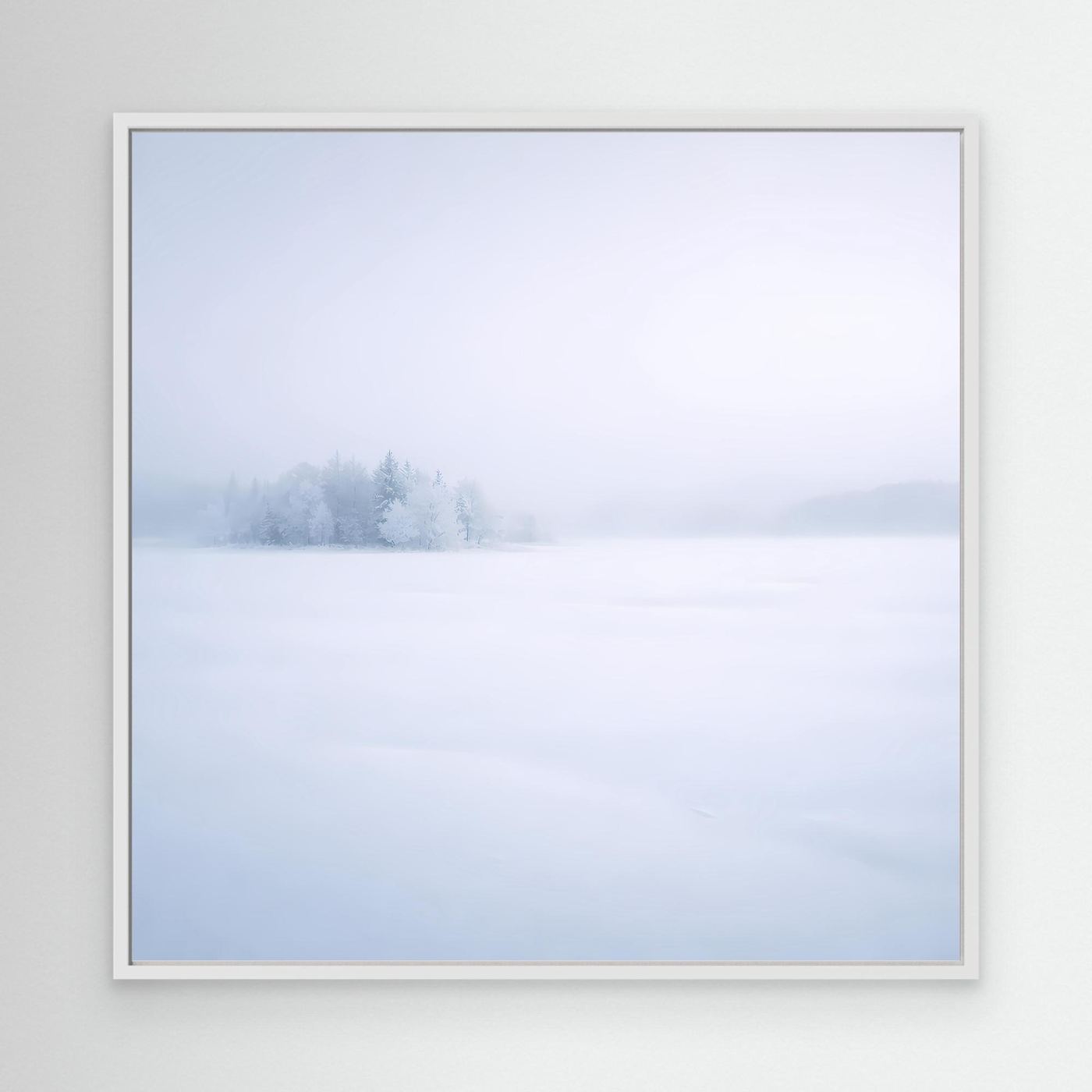 Leinwandbild mit Wintersee-Motiv im hellen Rahmen: verschneite Bäume im Nebel