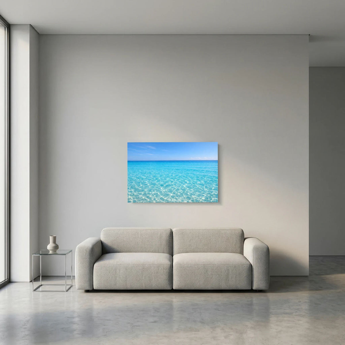 Kleines Meer-Wandbild im Querformat über einem grauen Sofa.