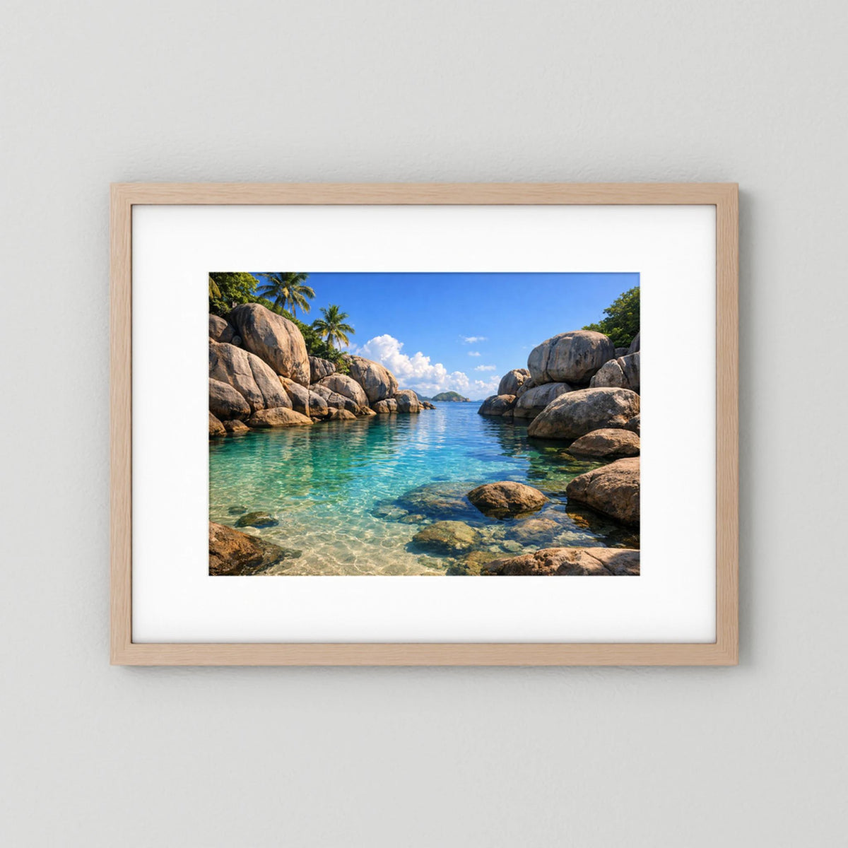 Querformatiges Wandbild mit tropischer Felsenbucht im Meer, heller Holzrahmen