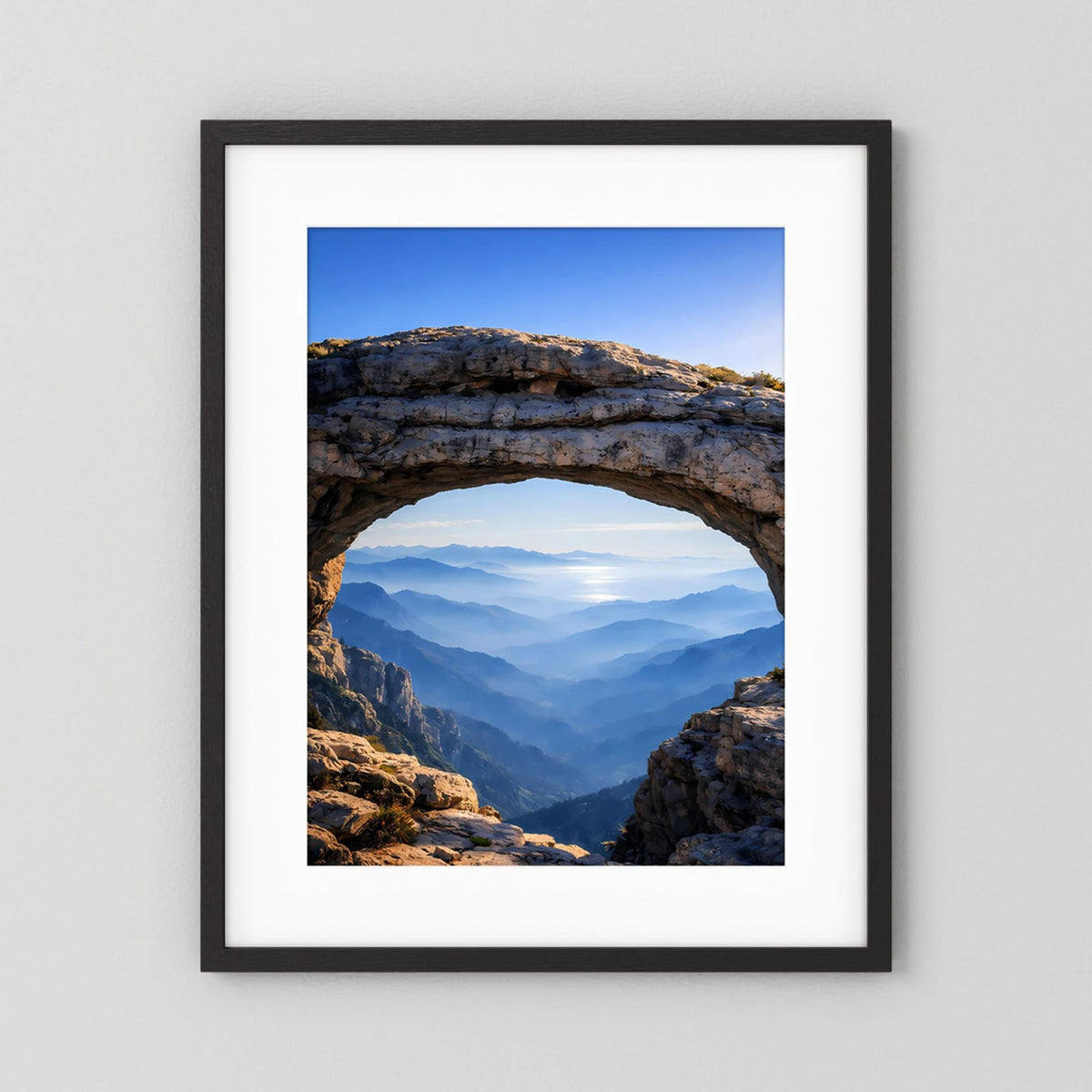 Hochformatiges Poster im schwarzen Rahmen mit weißem Rand und Felsbogen-Bergblick