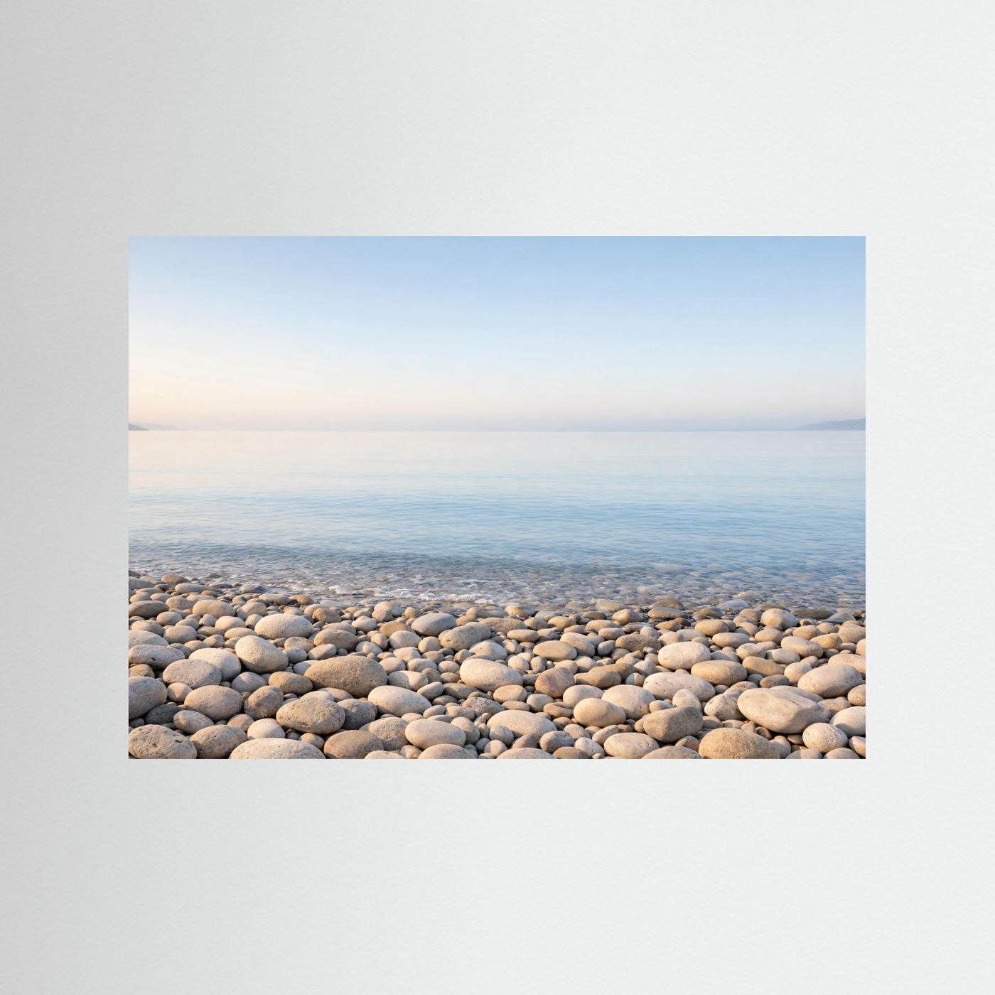 Panorama-Poster im Querformat: Steinstrand mit ruhigem Meer und Kieseln