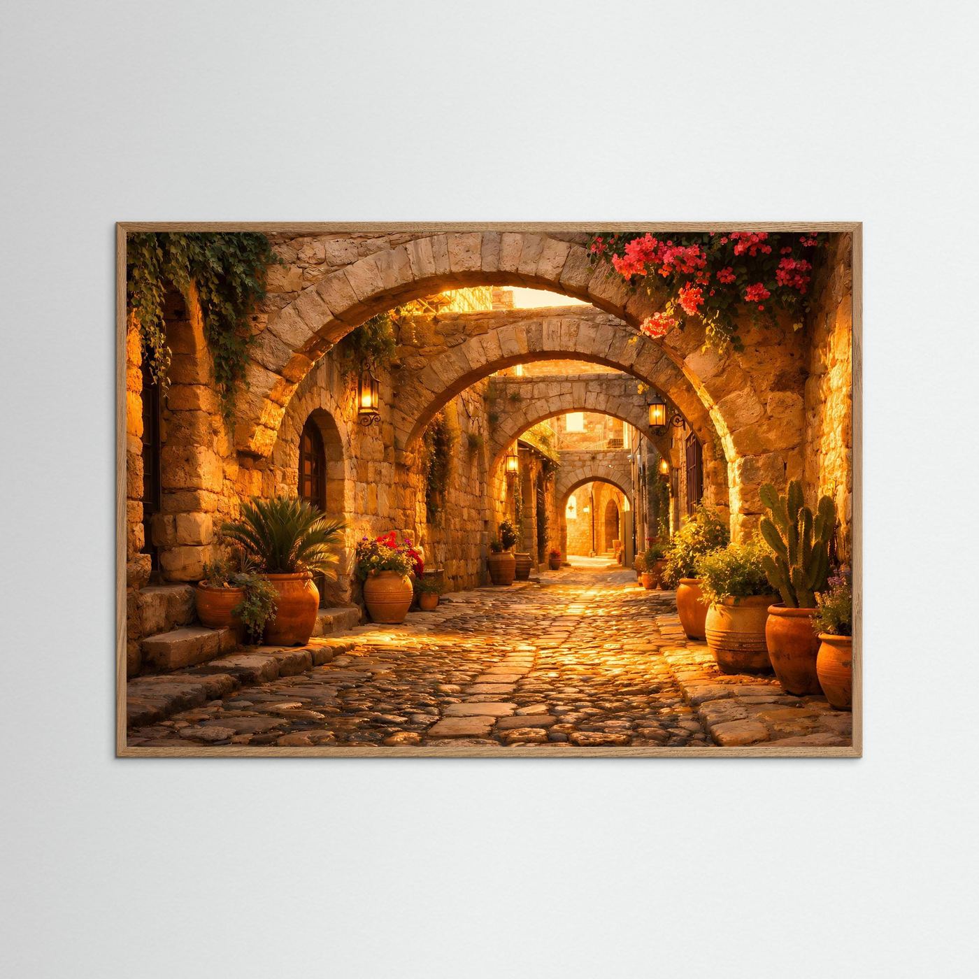 Wandbild mit mediterraner Gasse unter Steinbögen und roten Blüten; helle Holzrahmung.
