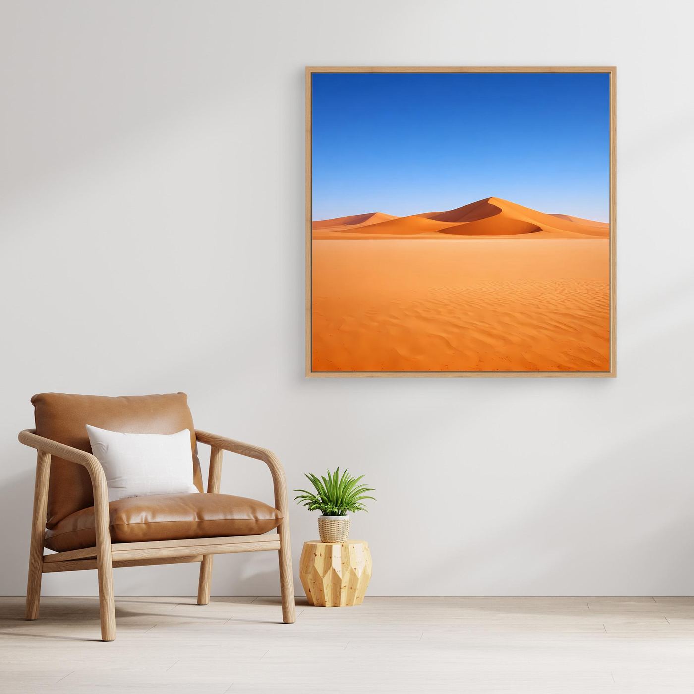Leinwandbild mit Sanddünen im braunen Rahmen, blauem Himmel und orangefarbenen Wüstenflächen.