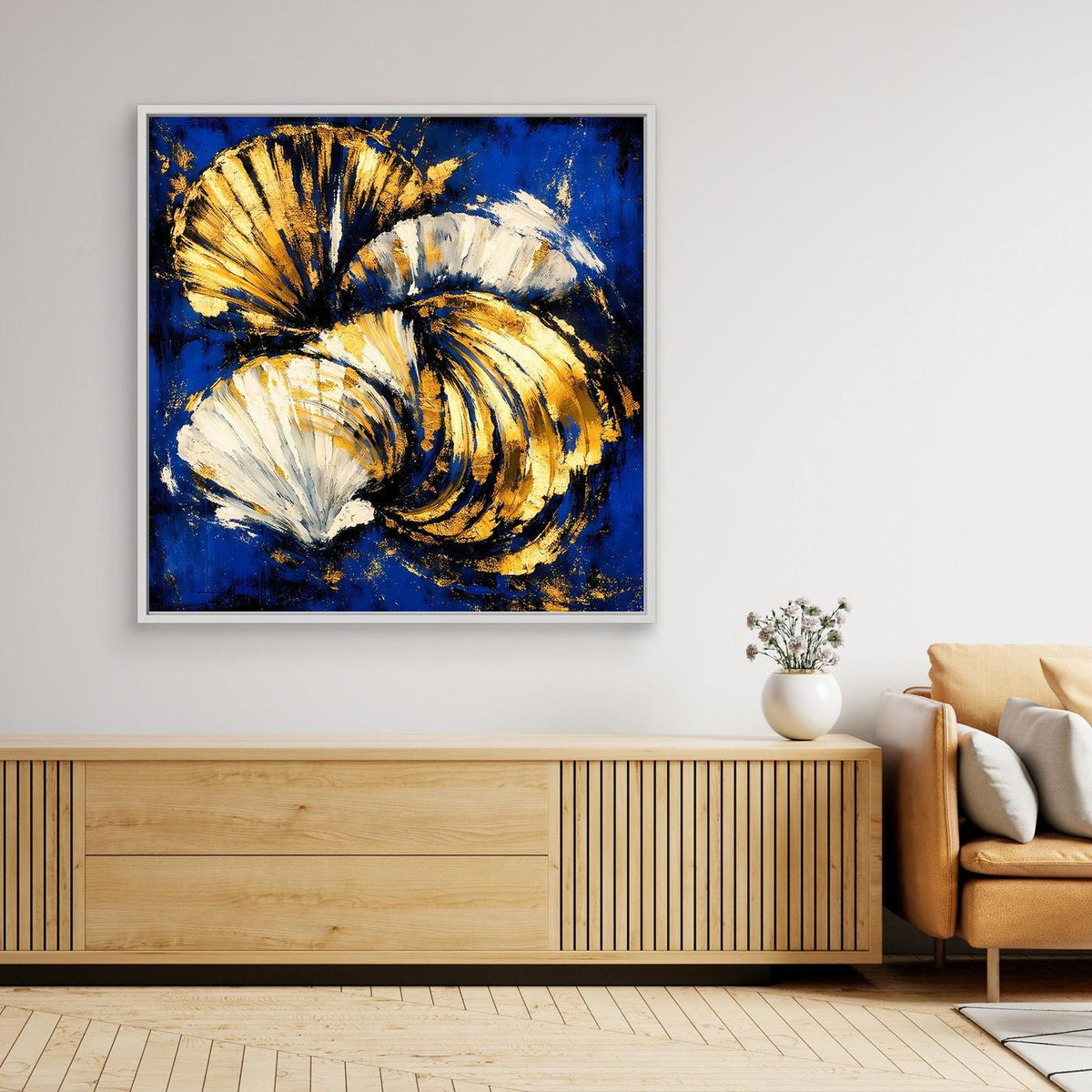 Abstraktes Muschel-Wandbild mit blauer Leinwand, gold-weißen Muscheln und weißem Rahmen