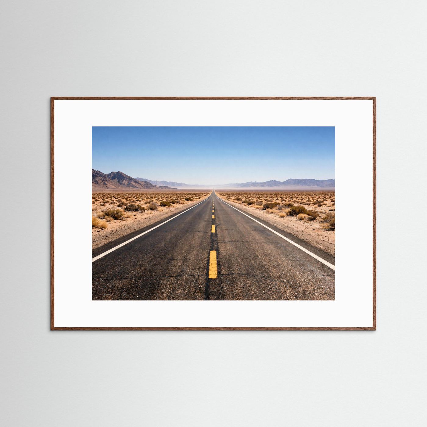 Wandbild mit Foto einer langen Straße durch die Wüste, im dunkelbraunen Holzrahmen